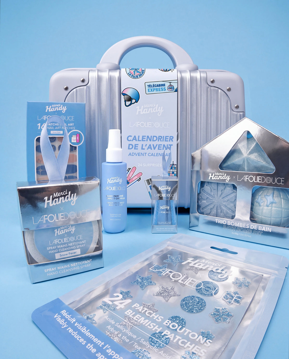 Édition Merci Handy × La Folie Douce™ – produits de la collection devant la valise du calendrier de l'Avent