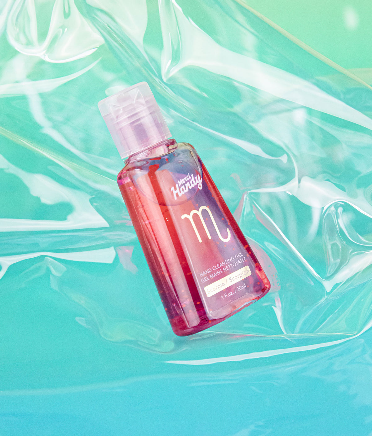 Gel Mains Nettoyant Scorpion Merci Handy – flacon sur fond turquoise irisé